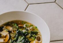 면역력 강화에 좋은 겨울철 전통 음식 a white bowl filled with soup on top of a tiled floor