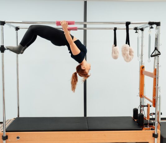유연성과 체형 교정, 꾸준한 운동의 효과 a woman doing a handstand on a pivot machine