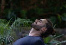 스트레스 해소와 체력 증진, 개인 맞춤형 PT의 중요성 a man sitting on a yoga mat in the middle of a forest