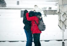 관계의 중요성: 사람들과의 연결 강화하기 person in red and black jacket and black pants carrying white dog on snow covered ground