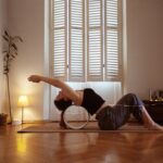 우아함의 완성, 데콜테 라인 : 승모근을 잠재우는 섬세한 설계 A woman is doing a yoga pose on a mat