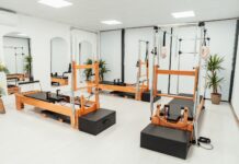 필라테스, 바쁜 일상 속 건강한 움직임 찾는 비결로 인기 a gym with a row of machines and mirrors