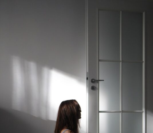 “마음 챙김이 가져오는 변화: 일상 속 스트레스 해소 실천법” a woman sitting on the floor in front of a door