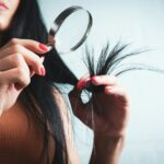 건강한 헤어 트렌드, 일상 습관이 좌우한다 Woman examining split ends of hair with magnifying glass