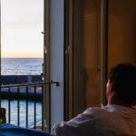 스마트 슬로우 라이프, 정신 건강을 지키는 새로운 흐름 Man looking out window at the ocean sunset