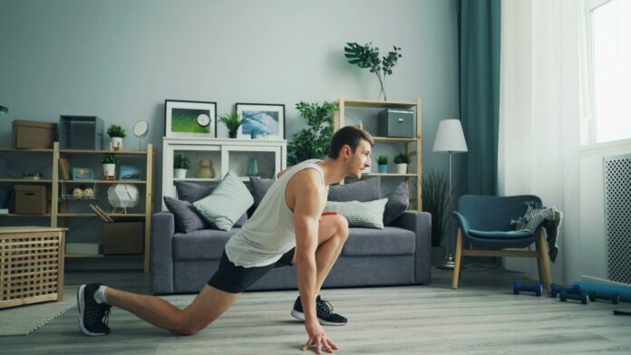 Photo by Vitaly Gariev a man is doing push ups in a living room